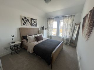 A serene bedroom with a cozy upholstered bed, elegant decor, and natural lighting in Solterra Texas by Cadence Homes (Mesquite, TX).