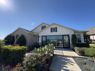 Model Home A modern farmhouse-style home with a landscaped front yard in Travisso by Taylor Morrison (Leander, TX).