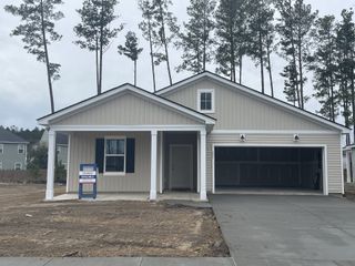 A charming single-story home with a covered porch and two-car garage in Sanctuary Cove at Cane Bay by Centex (Summerville, SC).