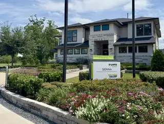 Street view A modern home with lush landscaping in Sienna 80′ by Tri Pointe Homes, Missouri City, TX.