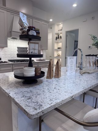 A modern kitchen with a speckled granite island, stylish cabinetry, and warm lighting for a cozy ambiance.