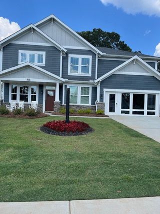 A charming gray and white home with a landscaped yard in Sweetbay Farm by Fischer Homes (Lawrenceville, GA).