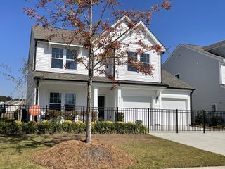 A charming white two-story home with a fenced yard in Village at Northtown by KB Home (Pflugerville, TX).