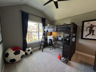 Model Home A cozy kids' room with soccer-themed decor, a loft bed, gray walls, and a study area. Perfect for young sports enthusiasts.