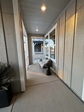 A cozy porch with warm lighting, comfortable seating, and decorative plants for a welcoming outdoor space.