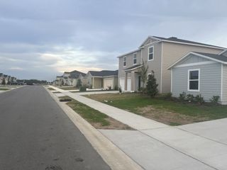 A charming neighborhood street with modern homes in Marion Ranch Townhomes by Lennar (Ocala, FL).