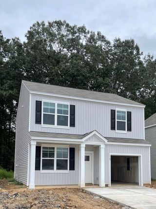 A charming gray two-story home with black shutters in Back River Bend by D.R. Horton (Goose Creek, SC).