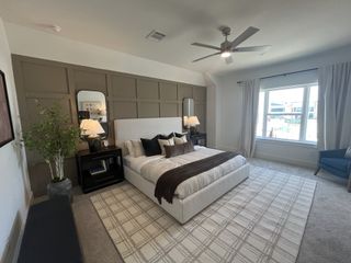 A serene bedroom with a cozy upholstered bed, elegant decor, and natural lighting in Solterra Texas by Cadence Homes (Mesquite, TX).