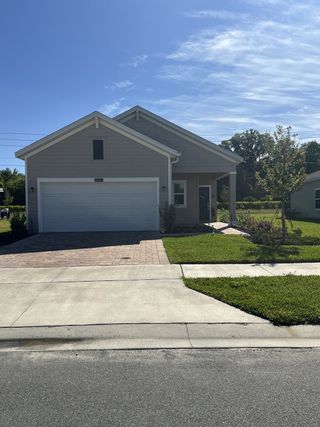 A charming, modern gray home with a spacious garage and manicured lawn in Millwood Estates - The Meadows by Lennar (Ocala, FL).