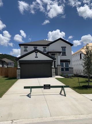 Street view A modern two-story home with a spacious driveway in Lakeside at Tessera on Lake Travis by Saratoga Homes (Lago Vista, TX).