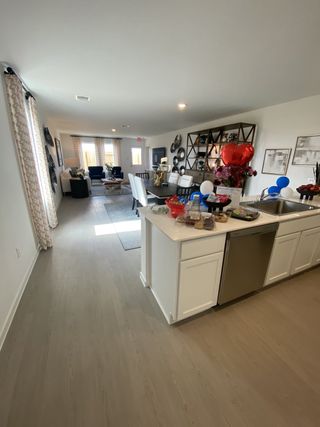 Model Home An open living area with modern decor, wood flooring, and a bright kitchen perfect for gatherings.