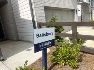 A contemporary home exterior with brick and stone accents in Rosewood Farms by D.R. Horton (Acworth, GA).