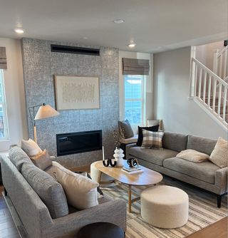 A cozy living room featuring a stylish gray sofa, modern fireplace, and chic decor in neutral tones.