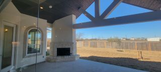 Model Home A spacious patio featuring a stone fireplace, vaulted ceiling, and expansive views for relaxed outdoor living.