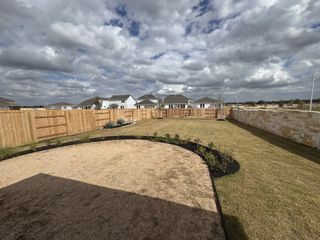 Expansive fenced yard with clear skies in Highcrest Meadow West by Tri Pointe Homes (Georgetown, TX).
