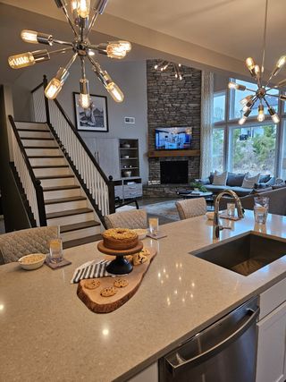 A cozy kitchen with warm lighting, a stone fireplace, and rustic-modern finishes, ideal for entertaining.