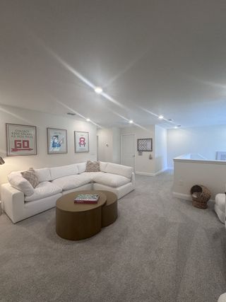 A cozy living room with a plush L-shaped sofa, round coffee tables, and game-themed wall art, perfect for relaxation.