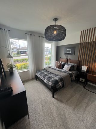 Model Home A stylish bedroom featuring a cozy bed with modern decor and a unique light fixture.