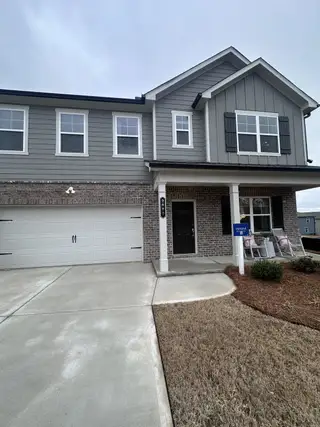 A modern two-story home with a brick facade and charming porch in Red Hawk Landing by Rausch Coleman Homes (San Antonio, TX).