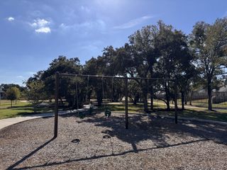 Community Amenities A scenic park with swings and large trees in Highland Village by Sitterle Homes, Georgetown, TX.