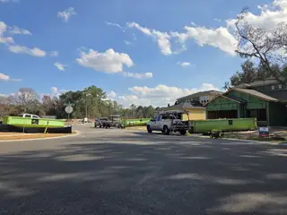 New homes under construction with green dumpsters in Wingate Landing by Pulte Homes (Jacksonville, FL).