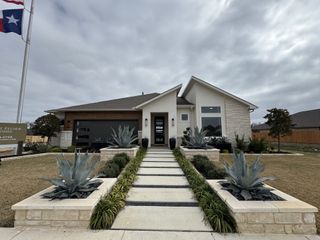 A modern home with sleek lines and desert landscaping in Meyer Ranch by Scott Felder Homes (New Braunfels, TX).