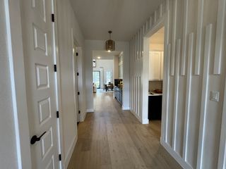A beautifully designed hallway with textured wall paneling, leading to an open-concept living space.