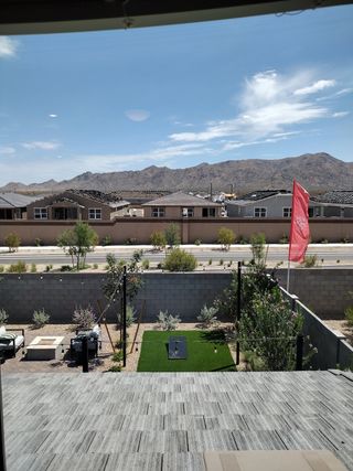 A serene backyard with a patio, greenery, and mountain views in The Residences Collection at Frontera by New Home Co. (Surprise, AZ).