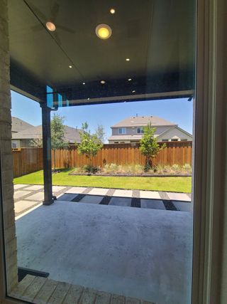 A modern patio with clean lines, recessed lighting, and a landscaped view through the window.