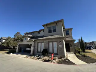 Street view A charming two-story home with modern design and a manicured front yard in Sonoma Heights by Coventry Homes (Round Rock, TX).