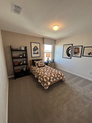 Cozy bedroom with modern decor, a single bed, stylish art, and a warm ambiance.