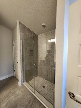 A modern bathroom with a glass-enclosed shower and elegant tilework throughout, creating a sleek and functional space.