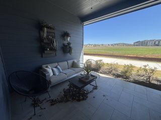 Street view A cozy patio with a beige sofa, wall plant decor, and scenic views, ideal for relaxation and enjoying nature.