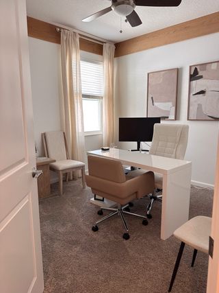 A modern home office with a sleek desk, ergonomic chair, and abstract art on the walls, featuring soft natural light.