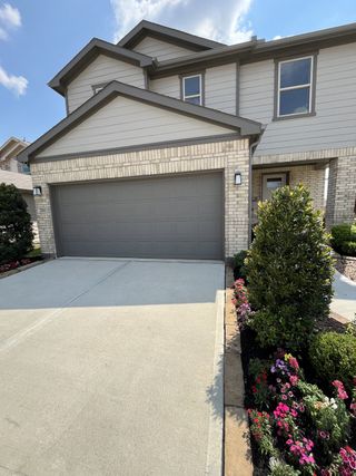 A modern two-story home with a sleek gray garage and lush landscaping in Bauer Meadows by KB Home (Hockley, TX).