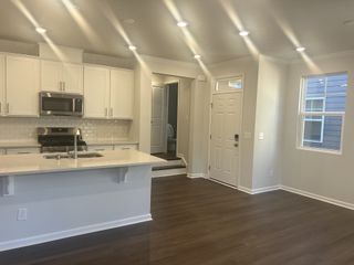 A modern kitchen with white cabinets, a subway tile backsplash, and sleek stainless steel appliances.
