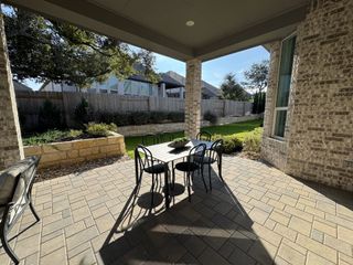 Model Home A spacious outdoor patio with stylish seating and a view of the meticulously maintained backyard.