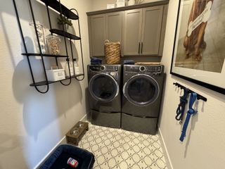 A beautifully designed laundry room with custom cabinetry, stylish tile flooring, and pet-friendly features.