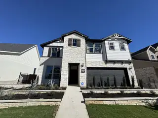 Elegant modern home with stone accents and manicured landscaping in Saddleback at Santa Rita Ranch by Pulte Homes (Liberty Hill, TX).