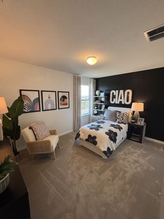 Model Home A cozy bedroom featuring a bold black accent wall, stylish decor, and natural light for a modern, inviting vibe.