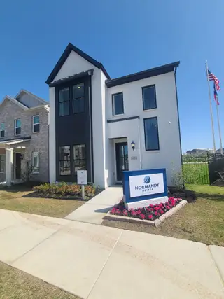 A modern white home with striking black accents in Twin Creeks Watters by Normandy Homes (Allen, TX).