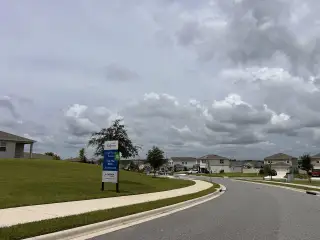 A serene neighborhood street in Ridgeview by Landsea Homes, Clermont, FL, with well-maintained sidewalks and lush greenery.