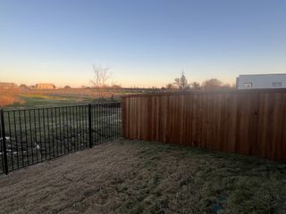 Spacious backyard with a wooden and metal fence in Foree Ranch: Watermill Collection by Lennar (Providence Village, TX).