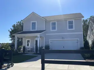 Street view A beautiful two-story home with a cozy porch and manicured lawn in Heron's Walk at Summers Corner by Lennar (Ridgeville, SC).