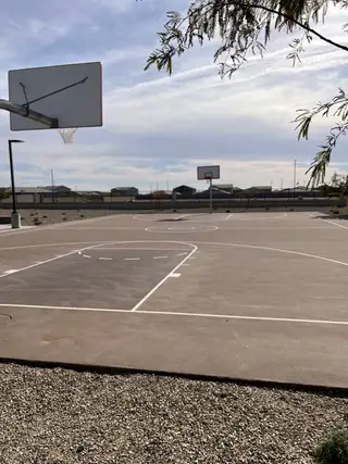 A nearby basketball court with clear skies offers recreation at The Vistas Collection at Village at Sundance by Century Communities (Buckeye, AZ).
