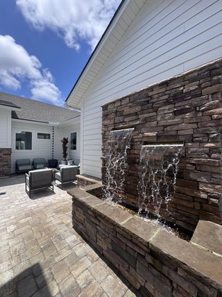 A charming patio with a stone water feature and cozy seating area, perfect for relaxation.