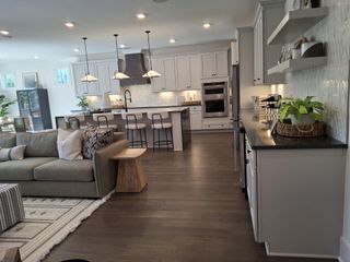 Model Home A spacious open kitchen and living area with sleek cabinetry, modern lighting, and cozy seating.