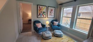 A cheerful bonus room with vibrant decor, cozy seating, and large windows, creating the perfect relaxation or play area.