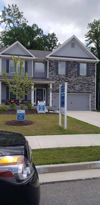 A charming stone-accented home with a lush yard in Paces Estates by McKinley Homes (Lithia Springs, GA).
