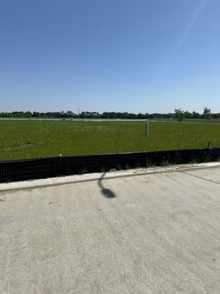 Open grassy field under a clear blue sky in Crosby Farms by Lennar (Crosby, TX).